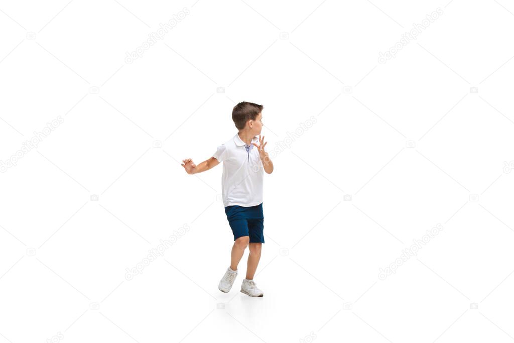 Happy little caucasian boy jumping and running isolated on white background