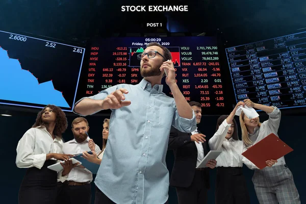 Нервові напружені інвестори аналізують кризовий фондовий ринок з графіками на екрані на фоні, падіння фондової біржі — стокове фото