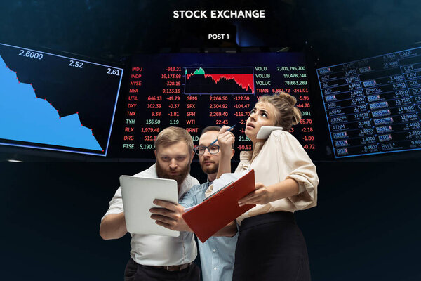 Nervous tensioned investors analyzing crisis stock market with charts on screen on background, falling stock exchange