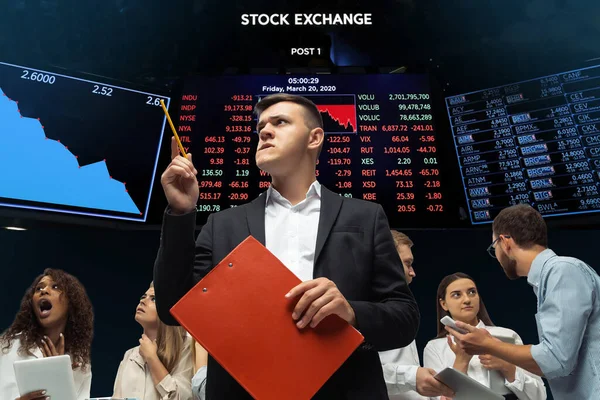 Нервно напряженные инвесторы, анализирующие кризис фондового рынка с графиками на заднем плане, падающей фондовой бирже — стоковое фото