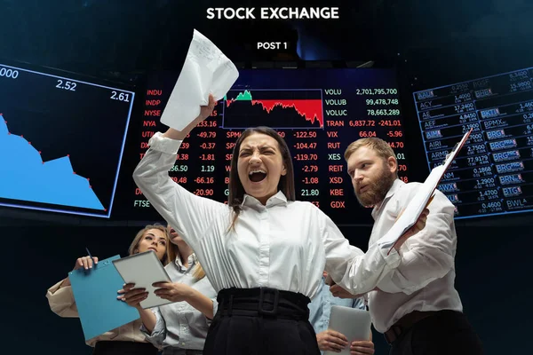 Nervous tensioned investors analyzing crisis stock market with charts on screen on background, falling stock exchange