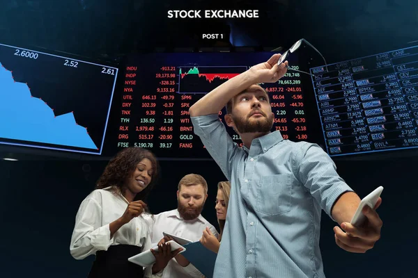 Nervous tensioned investors analyzing crisis stock market with charts on screen on background, falling stock exchange