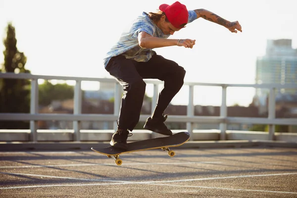 Skateboardista dělá trik na citys ulici v létě slunce — Stock fotografie