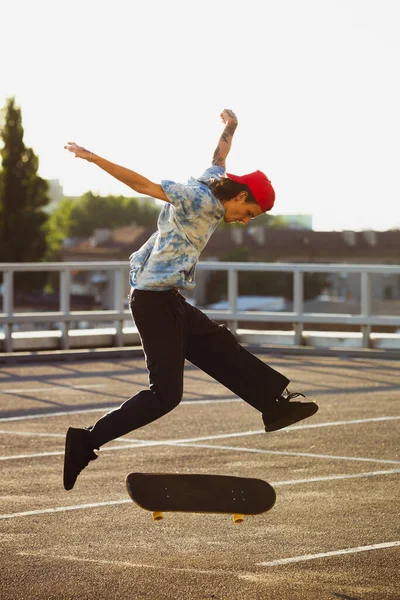 Skateboarder macht bei Sommersonne einen Trick auf der Straße — Stockfoto