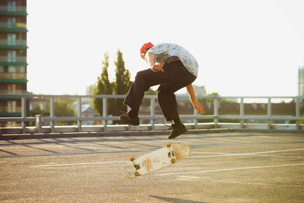 Skateboardista dělá trik na citys ulici v létě slunce — Stock fotografie