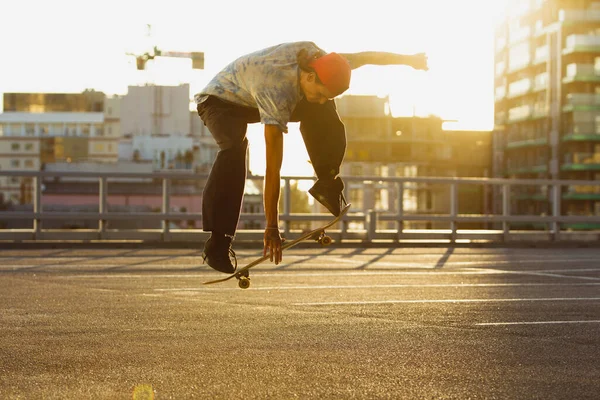 Skateboardista dělá trik na citys ulici v létě slunce — Stock fotografie