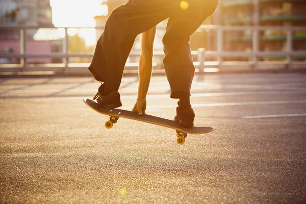 スケートボーダーは夏の日差しの中で街の通りでトリックをやって — ストック写真