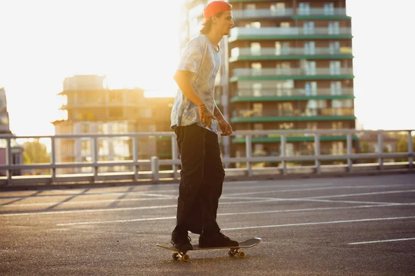 スケートボーダーは夏の日差しの中で街の通りでトリックをやって — ストック写真