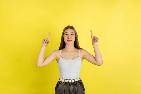 Niñas caucásicas retrato aislado en el fondo del estudio amarillo. Hermosa modelo femenina. Concepto de emociones humanas, expresión facial, ventas, publicidad, cultura juvenil . — Foto de Stock