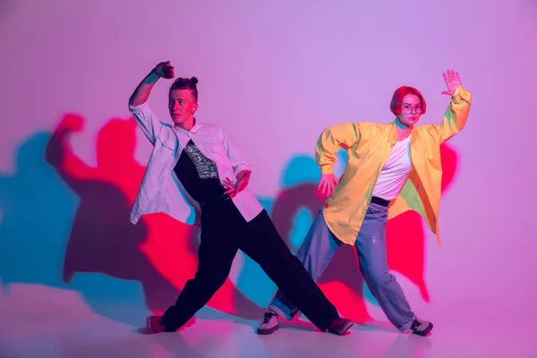 Junge Männer und Frauen tanzen Hip-Hop, Streetstyle isoliert auf Studiohintergrund in Neonlicht — Stockfoto