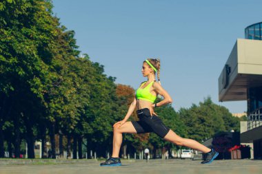 Kadın koşucu, sporcu güneşli yaz günlerinde açık havada antrenman yapıyor..
