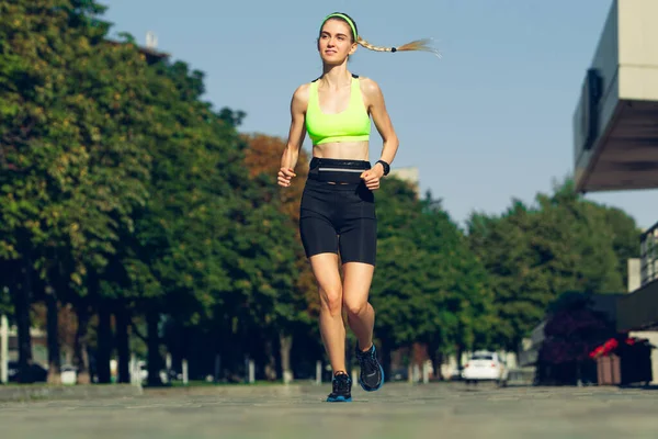 Female runner, athlete training outdoors in summers sunny day.