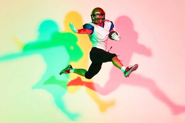 American football speler geïsoleerd op gradiënt studio achtergrond in neon licht met schaduwen — Stockfoto