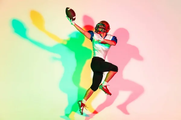 Amerikalı futbolcu, gölgeli neon ışıkta gradyan stüdyo arka planında izole edildi — Stok fotoğraf