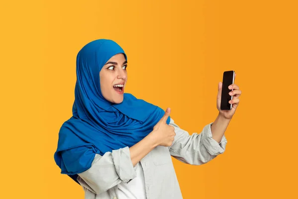 Retrato de jovem muçulmano mulher isolada no fundo do estúdio amarelo — Fotografia de Stock