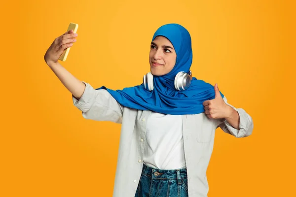 Portret van jonge moslim vrouw geïsoleerd op gele studio achtergrond — Stockfoto