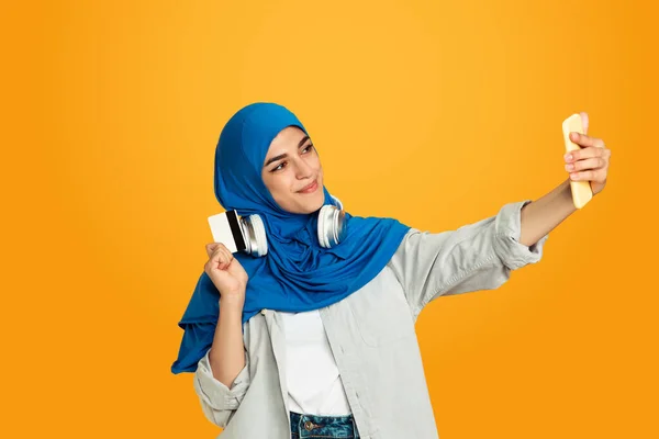 Retrato de una joven musulmana aislada sobre fondo amarillo del estudio —  Fotos de Stock