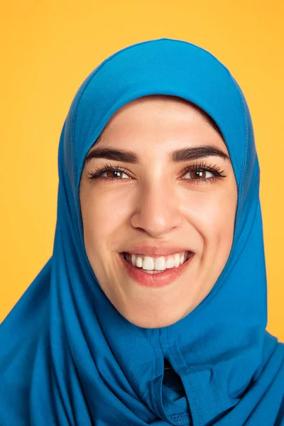 Πορτρέτο της νεαρής μουσουλμανικής γυναίκας απομονωμένη σε κίτρινο φόντο στούντιο — Φωτογραφία Αρχείου