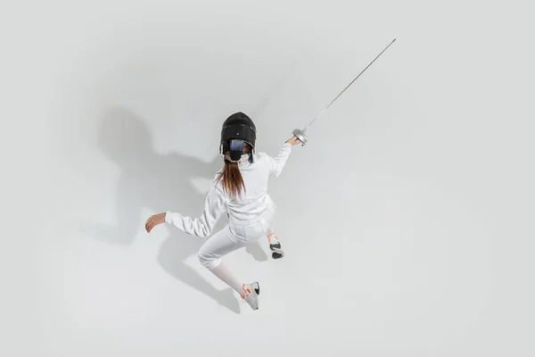 Nastolatka w stroju szermierki z mieczem w dłoni izolowane na białym tle, widok z góry — Zdjęcie stockowe