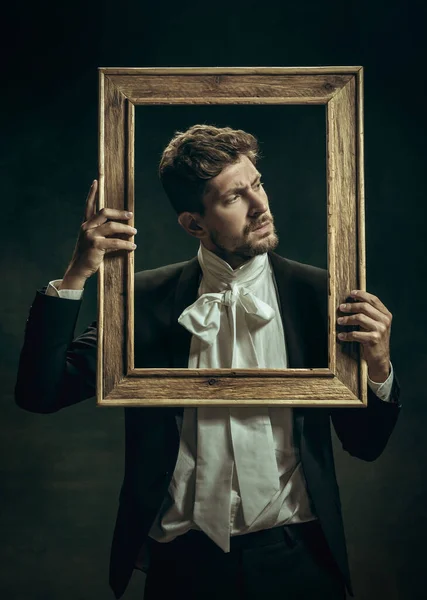 Junger Mann als Dorian Gray auf dunklem Hintergrund. Retro-Stil, Vergleich des Epochenkonzepts. — Stockfoto