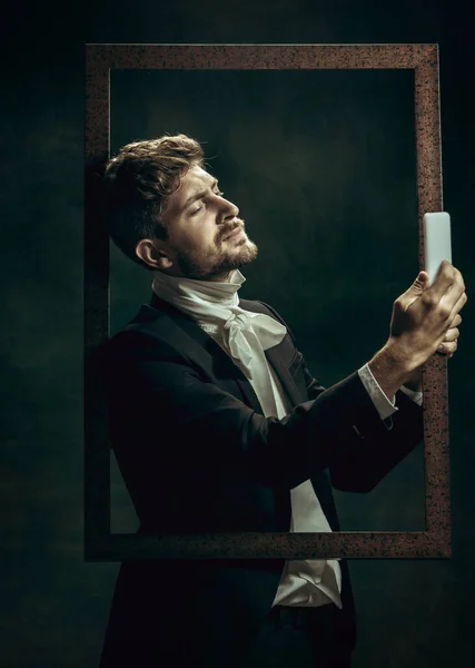 Mladý muž jako Dorian Gray na temném pozadí. Retro styl, srovnání konceptu éry. — Stock fotografie