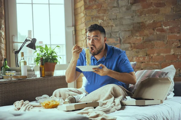 Hombre perezoso viviendo toda la vida en su cama rodeado de desorden — Foto de Stock