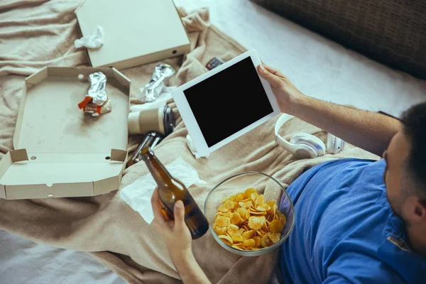 Lazy man living the whole life in his bed surrounded with messy