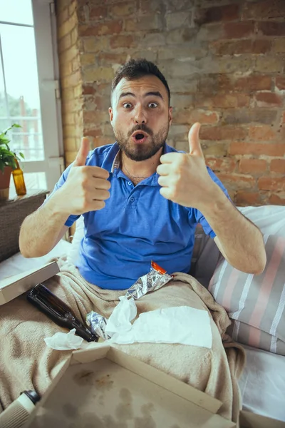 Hombre perezoso viviendo toda la vida en su cama rodeado de desorden — Foto de Stock