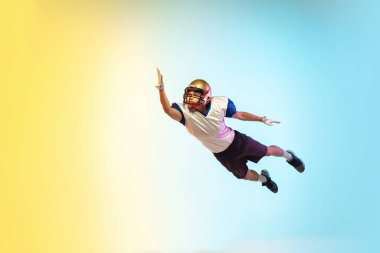 Amerikalı futbolcu, neon ışığı altında gradyan stüdyo arka planında izole edildi