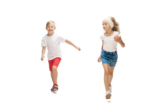 Ευτυχισμένο μικρό καυκάσιο κορίτσι και αγόρι πηδούν και τρέχουν απομονωμένοι σε λευκό φόντο — Φωτογραφία Αρχείου