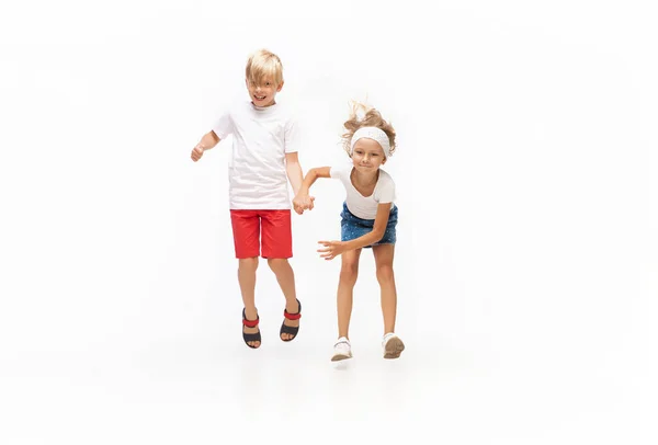 Feliz niña caucásica y chico saltando y corriendo aislado sobre fondo blanco — Foto de Stock