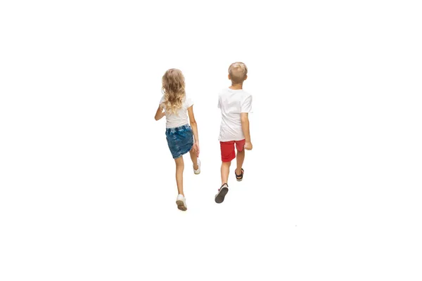 Feliz pouco caucasiano menina e menino pulando e correndo isolado no fundo branco — Fotografia de Stock
