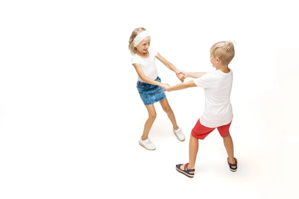 Feliz niña caucásica y chico saltando y corriendo aislado sobre fondo blanco — Foto de Stock