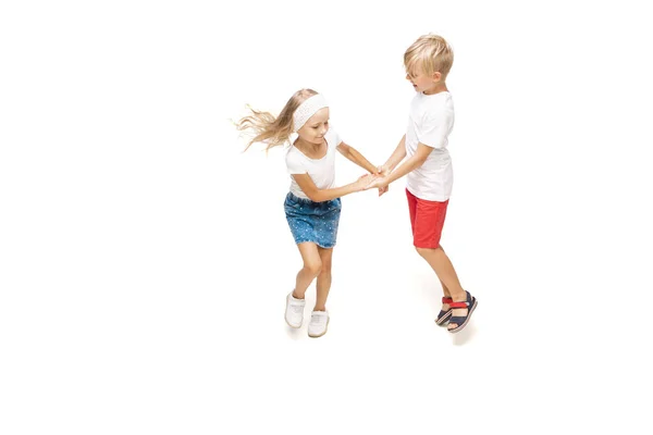 幸せな小さなcaucasian女の子と男の子ジャンプと実行孤立した上に白の背景 — ストック写真