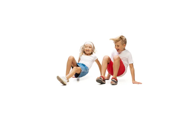快乐的小高加索女孩和男孩在白色背景下独自跳跃和奔跑 — 图库照片