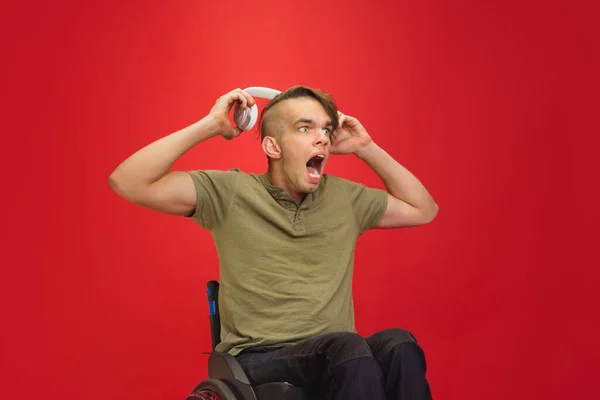 Retrato de hombre joven caucásico aislado sobre fondo rojo del estudio. Concepto de emociones humanas — Foto de Stock