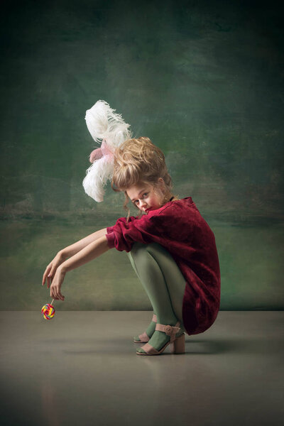 Young woman as Marie Antoinette on dark background. Retro style, comparison of eras concept.