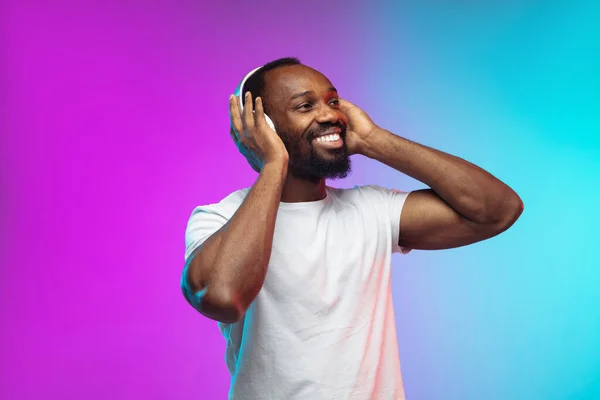 Afro-Amerikaanse jonge mannen portret op gradiënt studio achtergrond in neon — Stockfoto