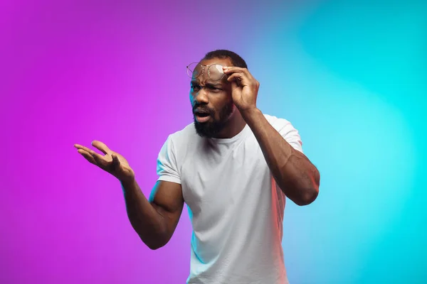 African-american young mans portrait on gradient studio background in neon — Stock Photo, Image