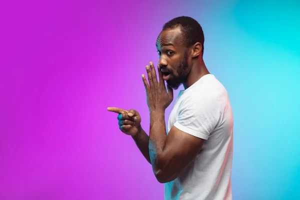 Afro-americano joven mans retrato en gradiente studio fondo en neón —  Fotos de Stock