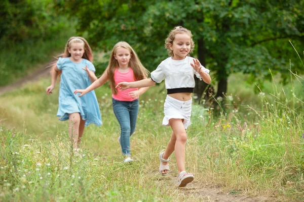 Niños, niños corriendo en el prado verde, bosque. Infancia y verano — Foto de Stock