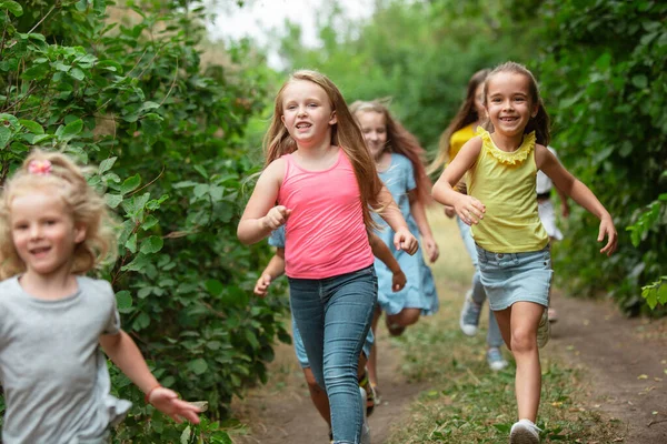 Les enfants, les enfants qui courent sur la prairie verte, la forêt. Enfance et été — Photo