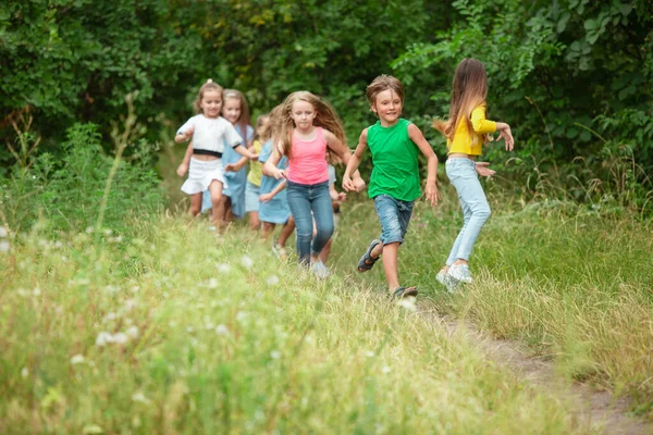 Niños, niños corriendo en el prado verde, bosque. Infancia y verano — Foto de Stock