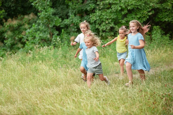 Crianças, crianças a correr no prado verde, floresta. Infância e horário de verão — Fotografia de Stock