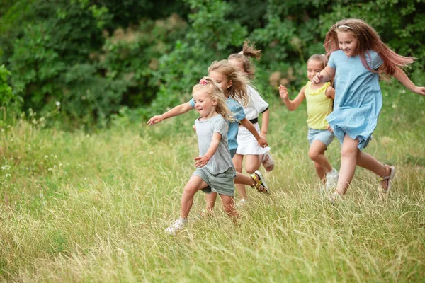 Kinder, Kinder, die auf der grünen Wiese laufen, Wald. Kindheit und Sommerzeit — Stockfoto