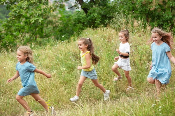 Kinder, Kinder, die auf der grünen Wiese laufen, Wald. Kindheit und Sommerzeit — Stockfoto