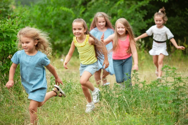 Les enfants, les enfants qui courent sur la prairie verte, la forêt. Enfance et été — Photo