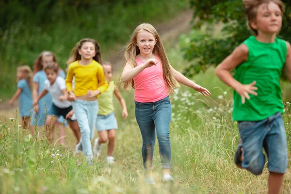 Niños, niños corriendo en el prado verde, bosque. Infancia y verano —  Fotos de Stock