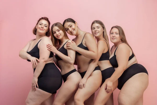 Portret van mooie jonge vrouwen met verschillende vormen poseren op roze achtergrond — Stockfoto