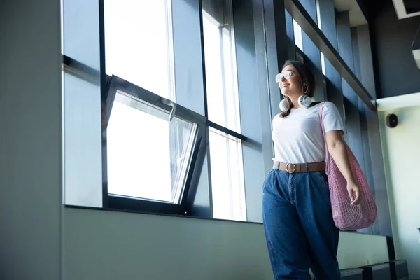 Giovane donna in attesa di partenza in aeroporto, viaggiatore con piccoli bagagli, stile di vita influenzatori — Foto Stock